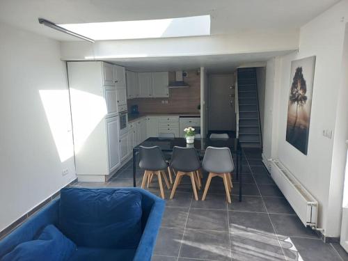 un salon avec un canapé bleu, une table et des chaises dans l'établissement Appt T2 Parking Jardin N7 motte, à Tourcoing