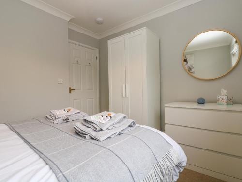 a bedroom with a bed with two towels on it at Heather's Cottage in Budock Water