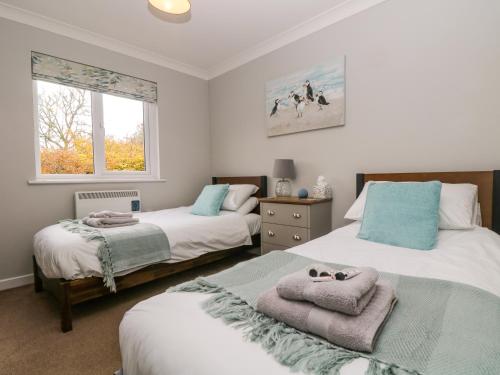 a bedroom with two beds with towels on them at Heather's Cottage in Budock Water