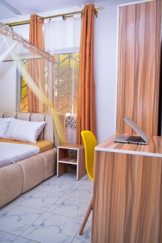 a room with a couch and a desk with a laptop at Private Villa & Tropical Garden Cottages near Bofa Beach - by Mango Tree Cottages Kilifi in Kilifi