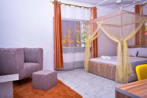 a bedroom with a canopy bed and a couch at Private Villa & Tropical Garden Cottages near Bofa Beach - by Mango Tree Cottages Kilifi in Kilifi
