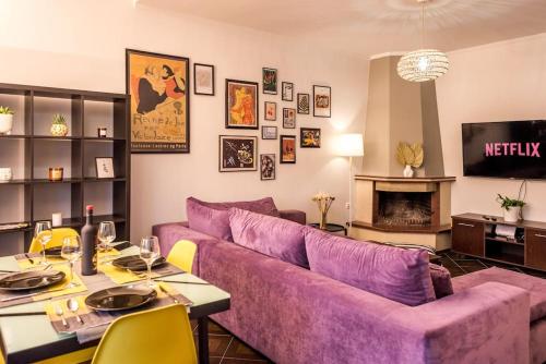a living room with a purple couch and a table at Athanasios 1 in Xanthi