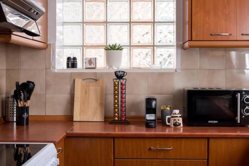 a kitchen counter with a microwave and a window at Athanasios 1 in Xanthi