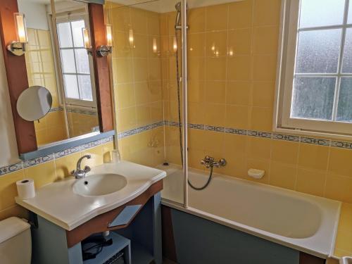 une salle de bain avec un lavabo, une douche et une baignoire dans l'établissement Le Nid du Bocage, à Saint-Hilaire-de-Talmont