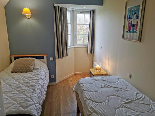 une chambre avec deux lits et une fenêtre dans l'établissement Le Nid du Bocage, à Saint-Hilaire-de-Talmont