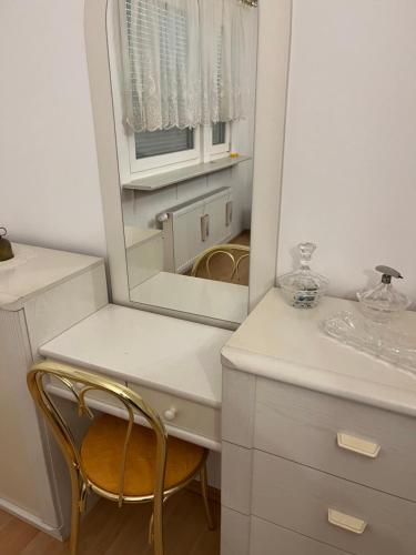 a bathroom with a vanity with a mirror and a chair at Waldtraum Wandlitzsee in Wandlitz
