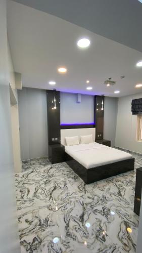 a bedroom with a large bed with a marble floor at Marina in Sohar