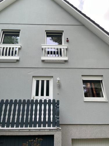 a gray house with two windows and a fence at Waldtraum Wandlitzsee in Wandlitz