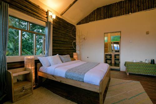 Una cama o camas en una habitación de Bwindi Orugano Lodge