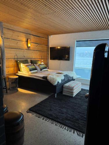 a bedroom with a large bed and a large window at Northern Lights River Nest in Rovaniemi