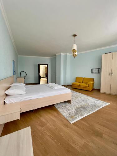 ein großes Schlafzimmer mit einem großen Bett und einem Sofa in der Unterkunft 205 Очень теплая 3 комн квартира у Байтерека с 3 большими кроватями и раскладным диваном для 1-8 человек in Astana