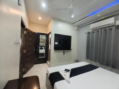 a hotel room with a bed and a television at Hotel Grandview in Kondapur