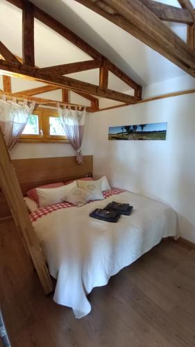 a bedroom with a white bed in a room with wooden ceilings at Ferienhaus am Bückeberg in Gernrode - Harz