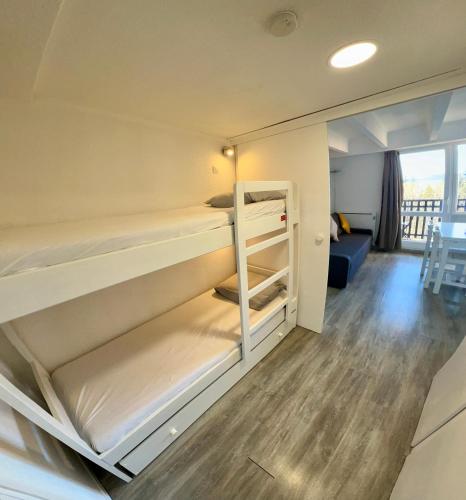 - une chambre avec 2 lits superposés et un salon dans l'établissement Location appartement Chamrousse 1650 - Superbe vue, à Chamrousse