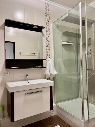ein Badezimmer mit Waschbecken und Glasdusche in der Unterkunft 205 Очень теплая 3 комн квартира у Байтерека с 3 большими кроватями и раскладным диваном для 1-8 человек in Astana