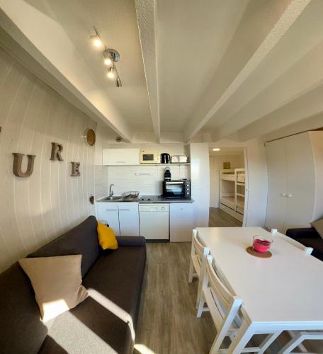 un petit salon avec une table et un canapé dans l'établissement Location appartement Chamrousse 1650 - Superbe vue, à Chamrousse