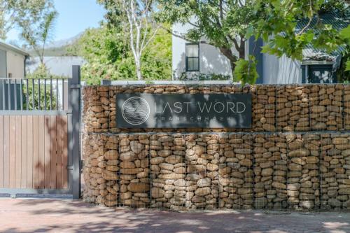 a retaining wall with a sign for the last word at Last Word Franschhoek in Franschhoek