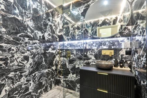 La salle de bains est pourvue d'un mur en marbre noir et blanc. dans l'établissement #6 1BDR Buffa 2 min from the beach and Negresco,central AC Balcony, à Nice