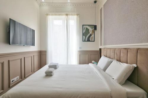 une chambre avec un grand lit avec une télévision à écran plat dans l'établissement #6 1BDR Buffa 2 min from the beach and Negresco,central AC Balcony, à Nice