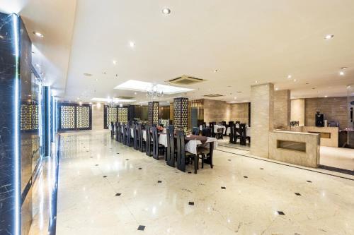 a dining room with tables and chairs in a restaurant at Alaya Stays Hotel Emperor Palms in New Delhi