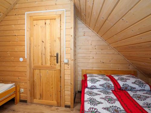 a bedroom with a bed in a wooden cabin at Chatki u Tadka - idealne dla rodzin i grupy znajomych - świetna lokalizacja, na przeciwko term Chochołowskich in Chochołów