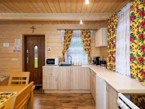 a kitchen with wooden cabinets and a counter top at Chatki u Tadka - idealne dla rodzin i grupy znajomych - świetna lokalizacja, na przeciwko term Chochołowskich in Chochołów