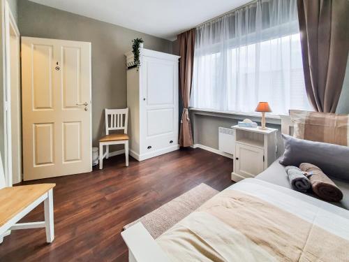 a bedroom with a bed and a window and a chair at Friendly Home - Villa Verde in Bornheim
