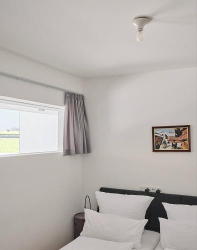 a bedroom with white walls and a bed with white pillows at Urban Mountain Splitlevel with Lake View in Maurach