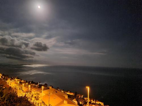 a view of a beach at night with the moon at Villa-Kasia Ocean View Studios in Caniço