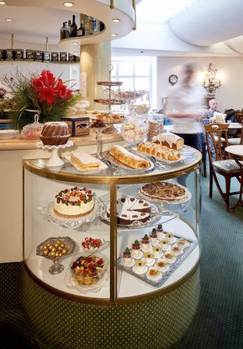 a display case filled with different types of cakes and pastries at Hotel Mozart in Rorschach