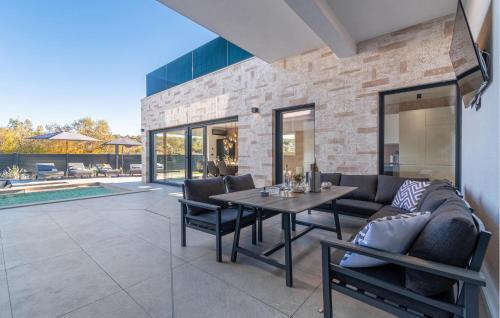 a patio with a couch and a table and chairs at Nice Home In Labin With Sauna in Labin