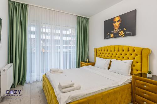 a bedroom with a large yellow bed with green curtains at Luxury Residences & Suites in Central Brasov at Coresi Mall in Braşov