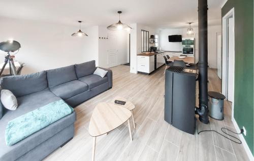 un salon avec un canapé bleu et une cuisine dans l'établissement Beautiful Home In La Plaine Sur Mer, à La Plaine-sur-Mer