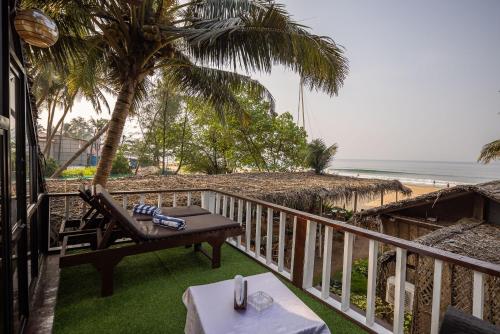 a balcony with a table and a chair and the beach at Forget Me Not Resort in Agonda