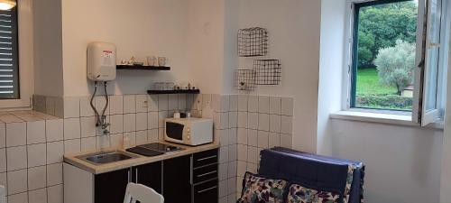 a small kitchen with a sink and a microwave at Villa Kamena in Kotor