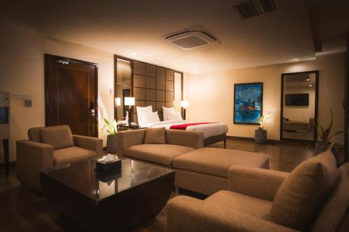 a hotel room with a bed and a living room at Rockville House managed & operated by Serai Boutique Hotels and Resorts in Islamabad