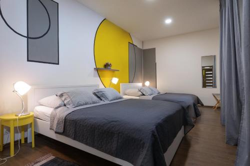 a bedroom with two beds and a yellow wall at Masiarska Apartment 1 Best Adress In City Center Kosice in Košice