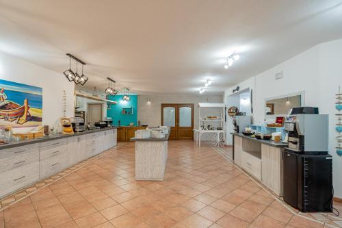 a large kitchen with white cabinets and a tile floor at I Ginepri Hotel in Cala Gonone