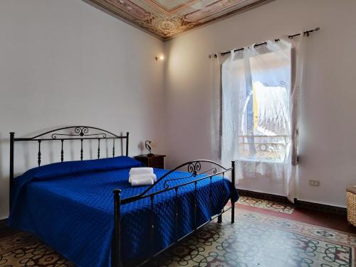 a bedroom with a blue bed and a window at Baia delle Sirene by Holiday World in Porticello