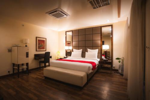a bedroom with a bed and a desk and a chair at Rockville House managed & operated by Serai Boutique Hotels and Resorts in Islamabad