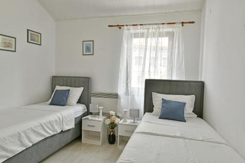 een slaapkamer met twee bedden en een raam bij Apartments Villa Herak in Poreč