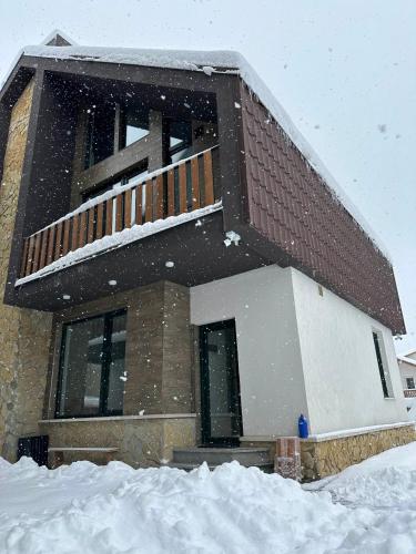 a house covered in snow in front at Bakuriani Cottages in Bakuriani