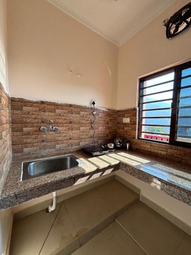 a kitchen with a sink and a window at Prakruti Homestay in Rishīkesh