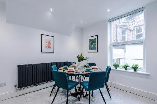 a dining room with a table and blue chairs at The Bridgeton In Harrogate - Parking - Garden in Harrogate