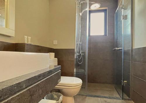 a bathroom with a toilet and a glass shower at El Gouna - BIRD NEST in Hurghada
