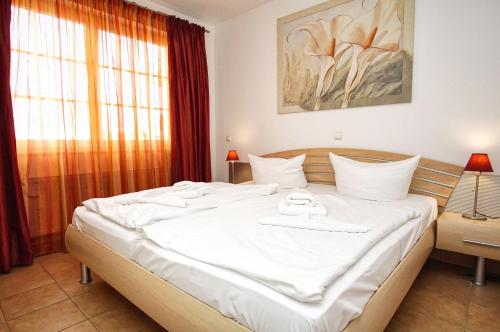 ein großes weißes Bett in einem Zimmer mit Fenster in der Unterkunft Strandvilla Böck FeWo 10 strandnah, Balkon, Meerblick in Glowe