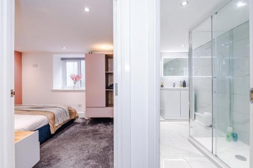 a bedroom with a bed and a glass shower at The Bridgeton In Harrogate - Parking - Garden in Harrogate