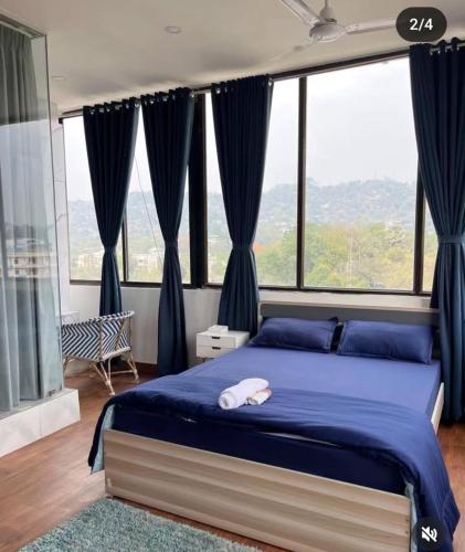 a bedroom with a blue bed with a large window at Pazuri in Ruiru