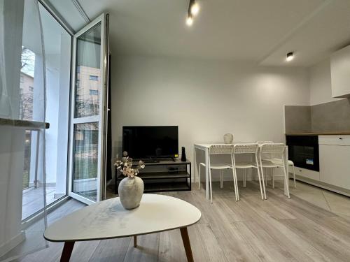 奥斯威辛Apartament Powstańców 17的带电视和桌子的客厅