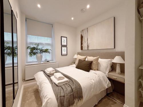 a bedroom with a large white bed and a window at Central Todmorden 2 Bedroom Apartment in Todmorden